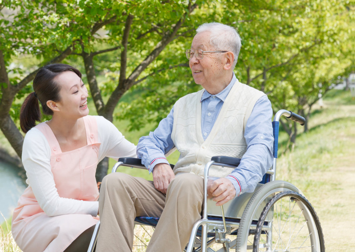 woman talking to senior male on wheelchair